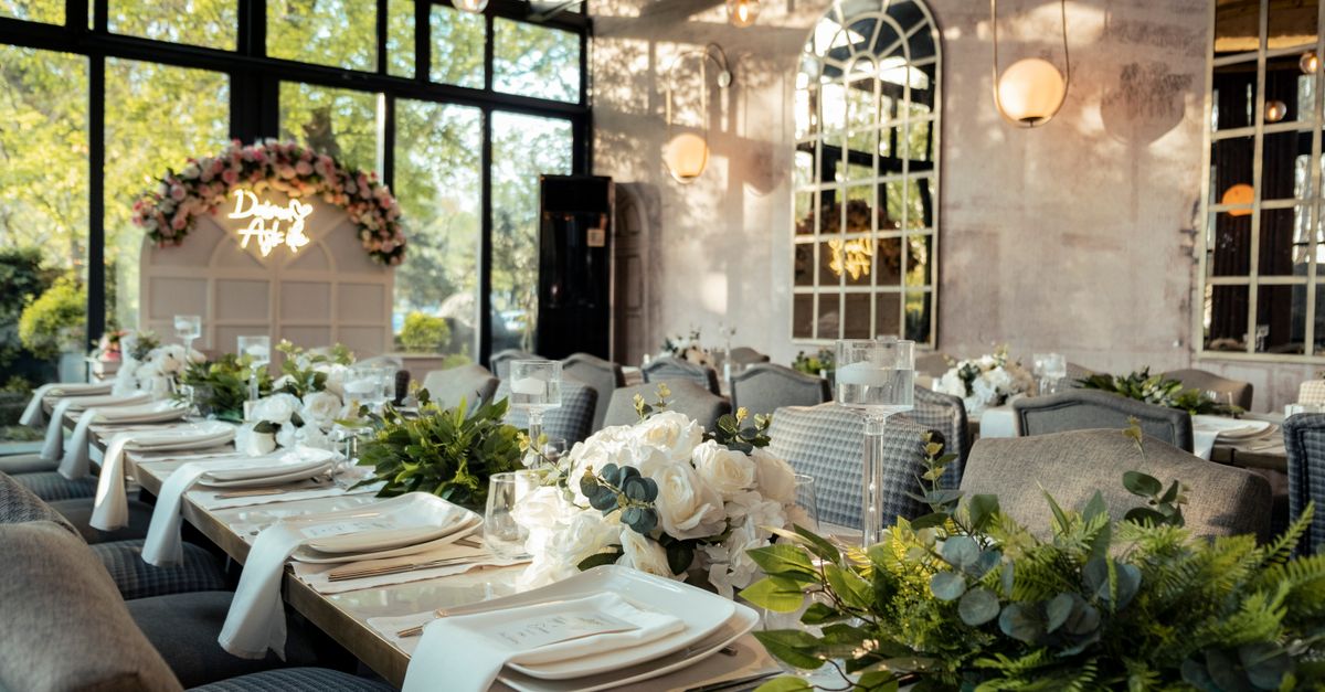 Beautifully decorated indoor wedding reception with flowers and elegant table settings.