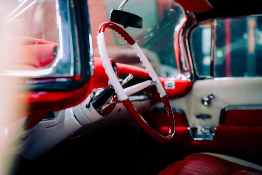 A detailed view of a classic car's interior with vibrant red and white accents.