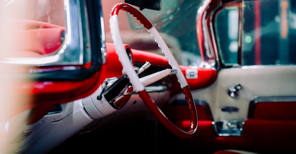 A detailed view of a classic car's interior with vibrant red and white accents.
