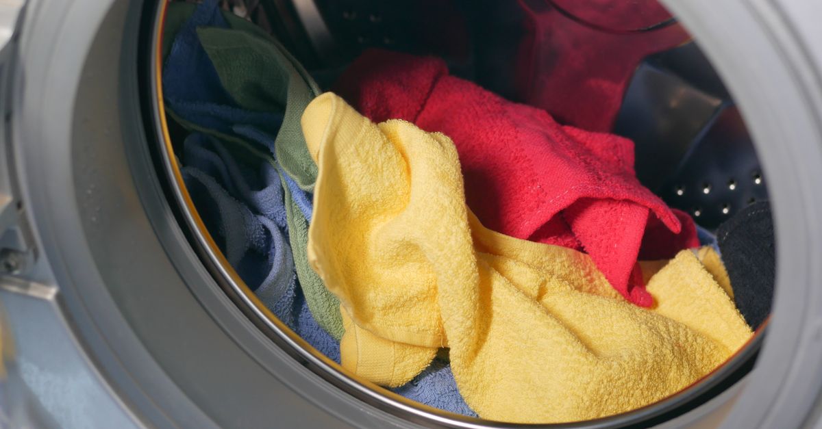 Vibrant close-up of multicolored towels inside a washing machine, ready for a wash.