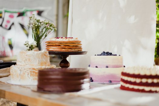 A variety of beautifully decorated cakes on stands, perfect for dessert lovers.