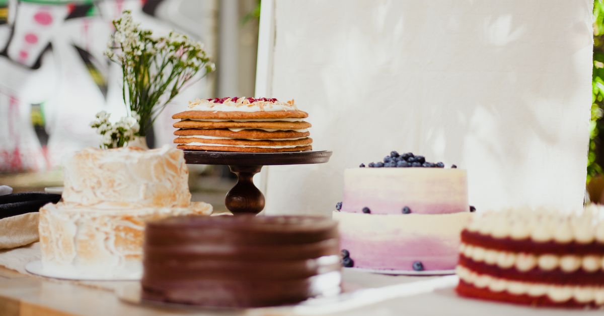 A variety of beautifully decorated cakes on stands, perfect for dessert lovers.