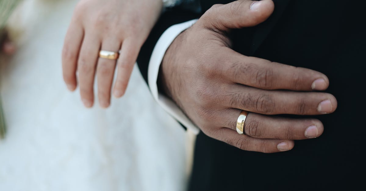 Close-up of bride and groom's hands with wedding rings, symbolizing love and commitment.