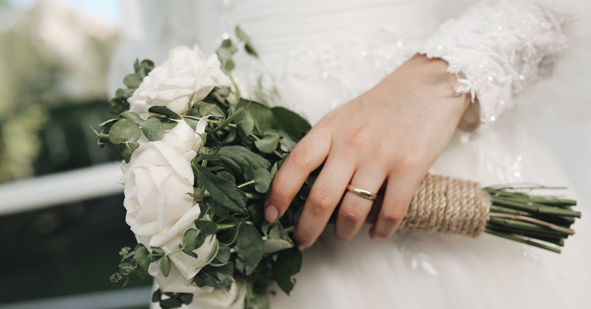 Close-up of a bridal bouquet with white roses and greenery in an elegant wedding setting.