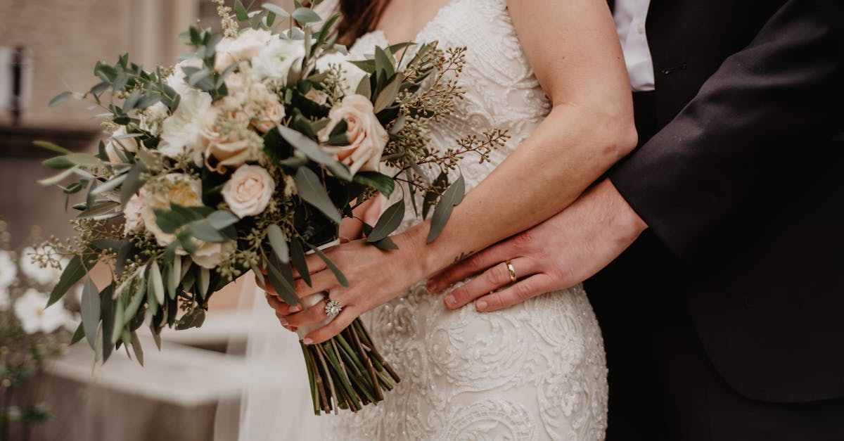 Lovely wedding scene showing a bride holding a bouquet and groom embracing, symbolizing love and togetherness.