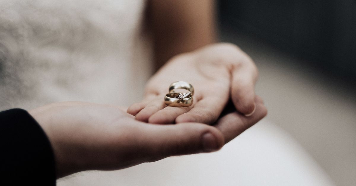 Bride holding wedding bands in a tender moment, symbolizing love and commitment.
