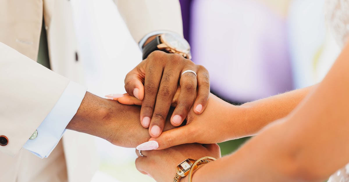 A symbolic gesture of unity, showing hands interlocked at a wedding ceremony.