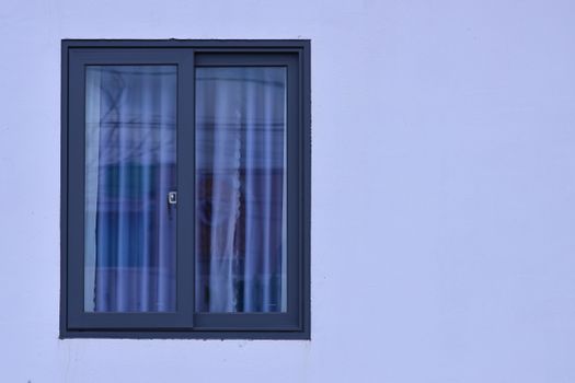 A minimalist view of a modern window with frosted glass on a light blue wall.