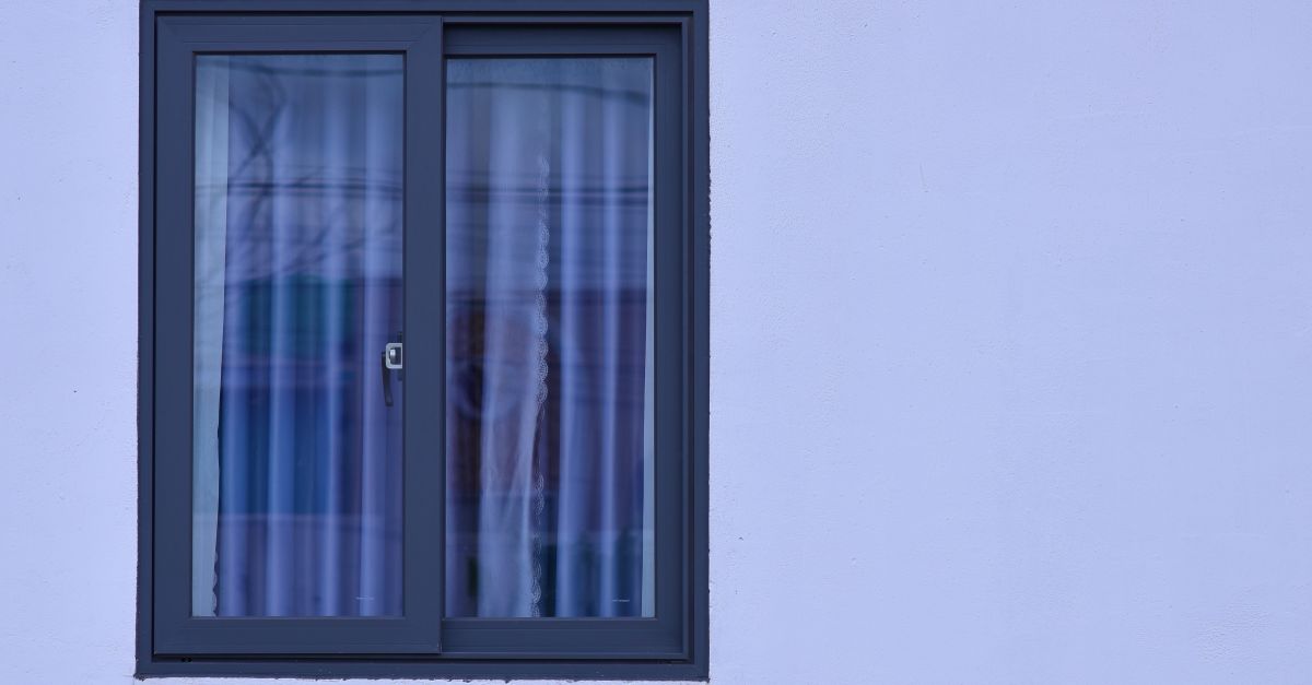 A minimalist view of a modern window with frosted glass on a light blue wall.