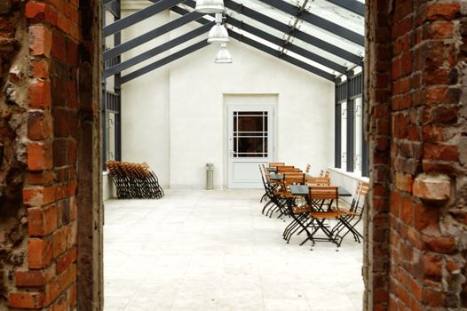 Cozy indoor dining space with wooden tables and chairs in a sunlit area.