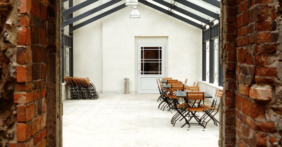 Cozy indoor dining space with wooden tables and chairs in a sunlit area.